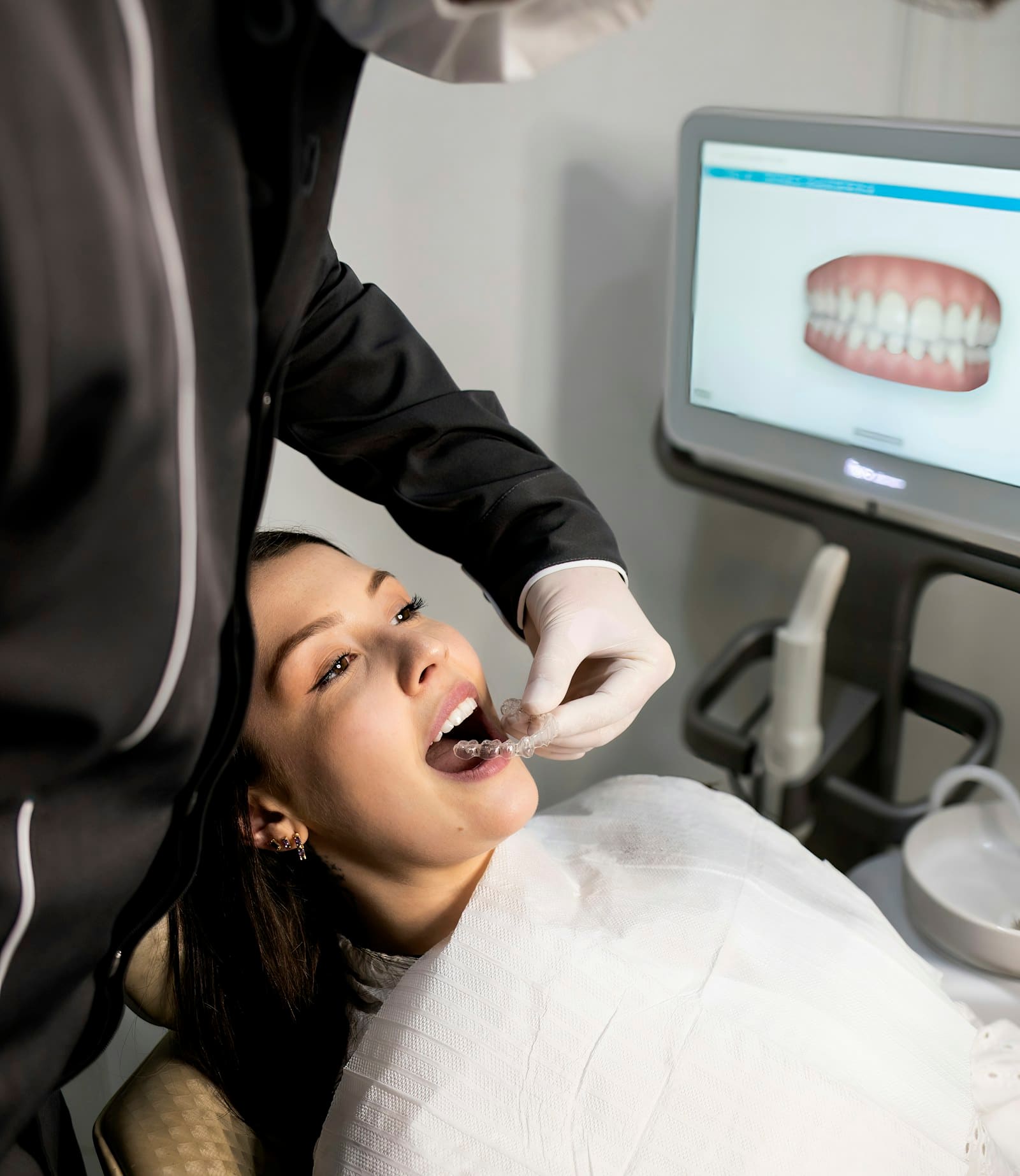A dentist at OK Dental Care checking a patient's teeth using a digital mouth scanner